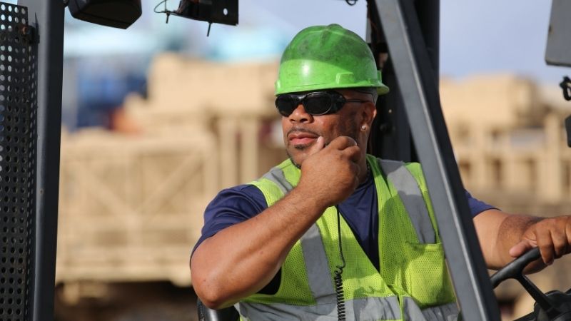 worker on a forklift using a radio