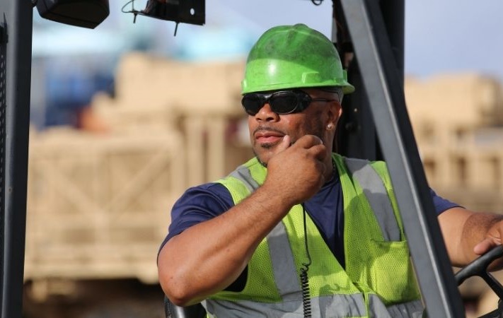 worker on a forklift using a radio