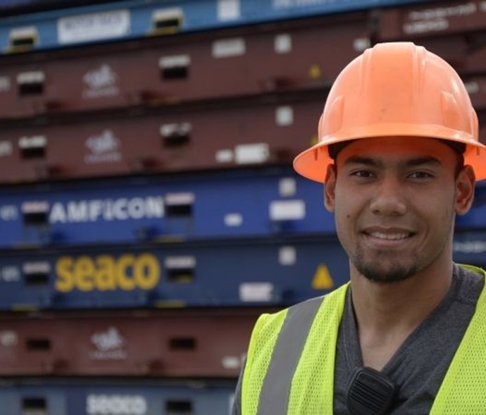 Man in a hard hat standing in front of cargo equipment