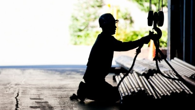 worker securing pipes in a sling