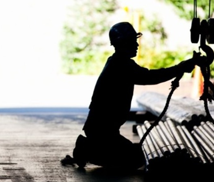 worker securing pipes in a sling