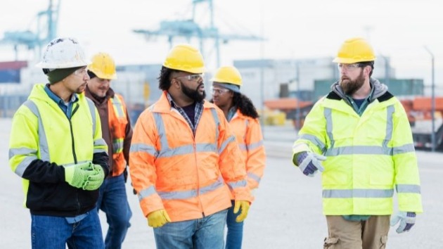 Group of workers walking across a cargo facility