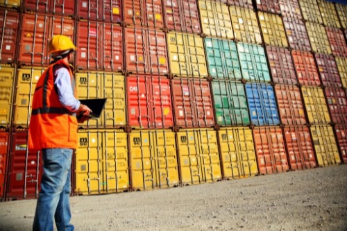 Worker in front of containers